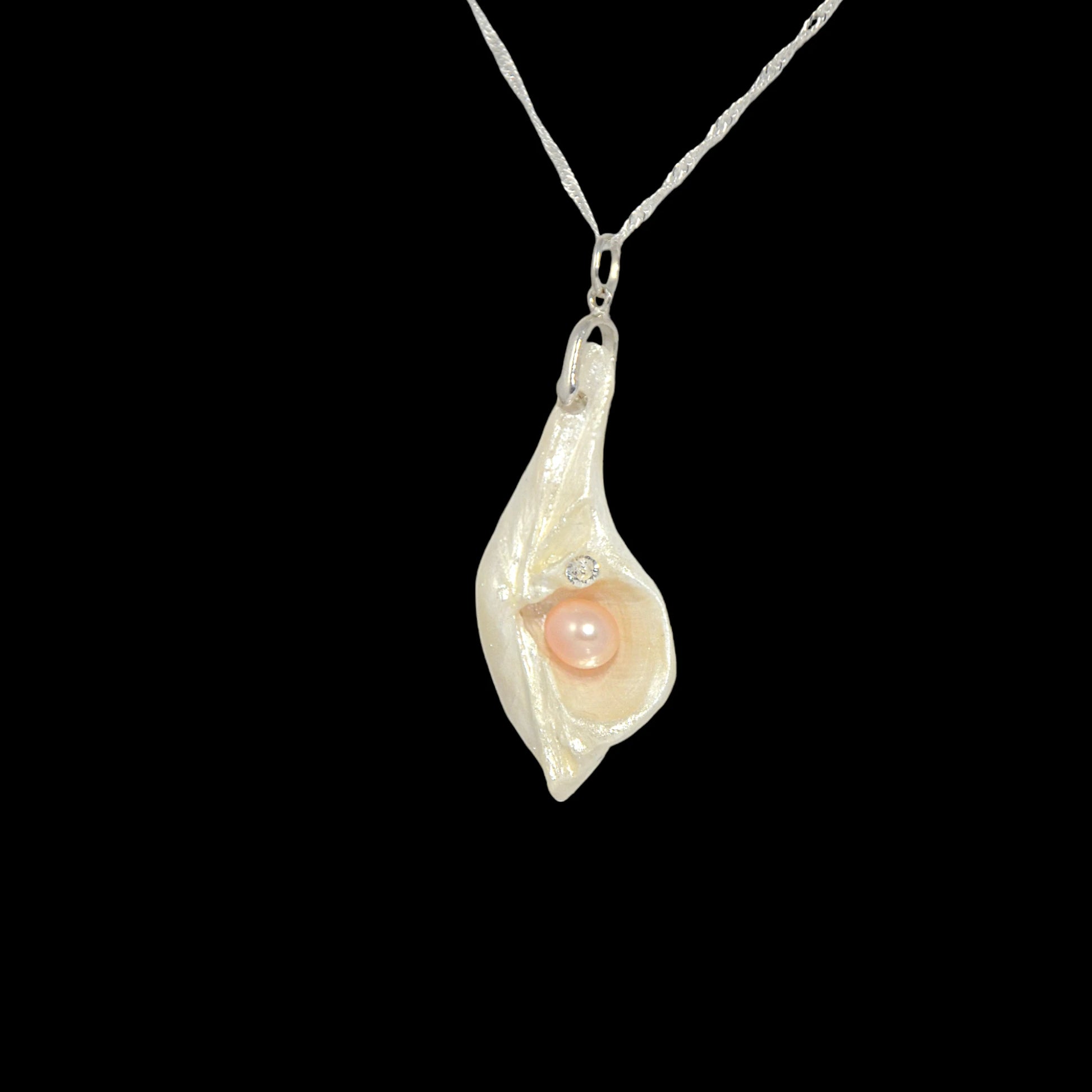 The pendant is showing the left side of the pendant so the viewer can see the pearl and herkimer diamond.