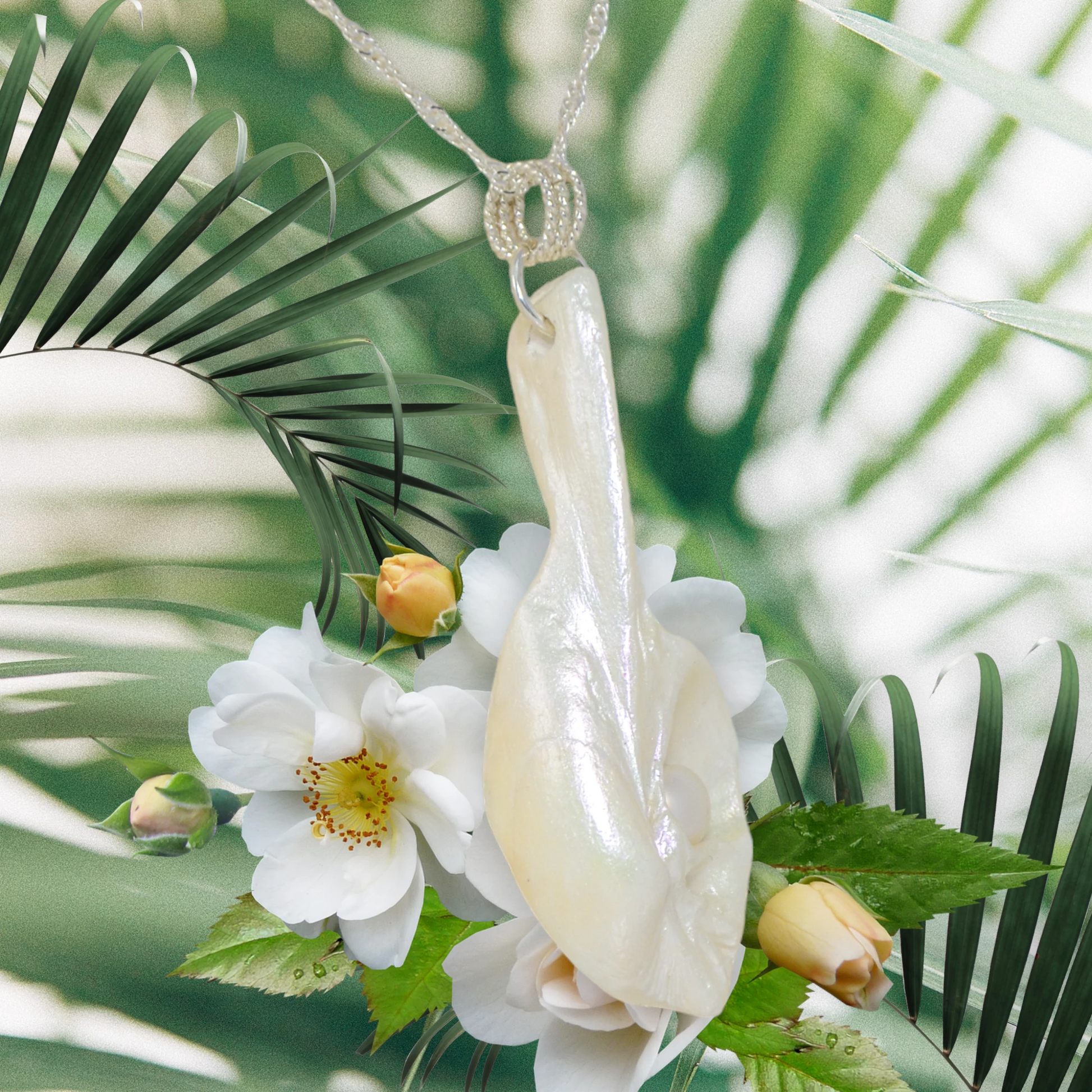 Amara is the name of this one of a kind pendant made from a natural seashell from the beach of Vancouver Island.  The pendant has a real freshwater pearl.  The pendant is being showcased showing the right side of the pendant.