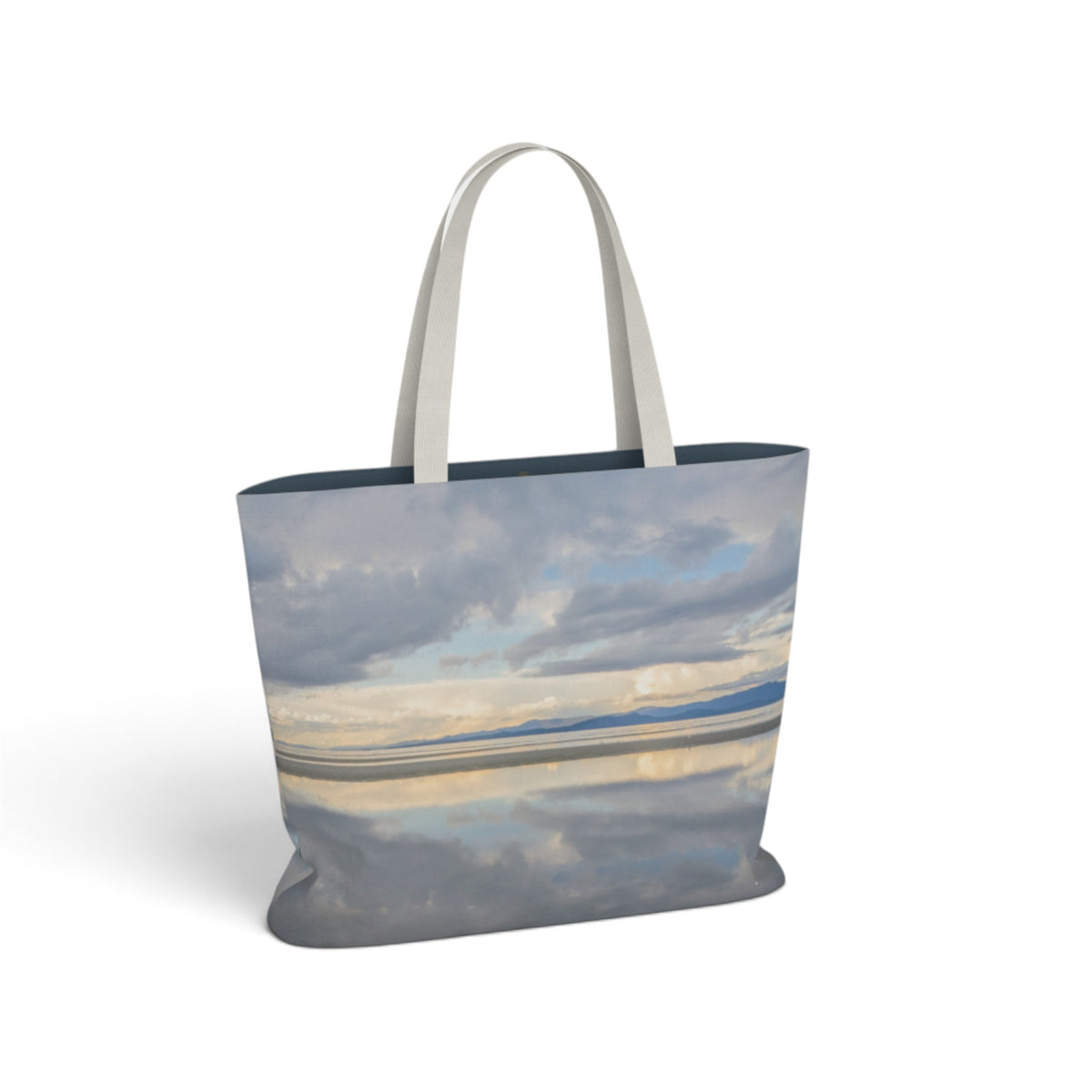 A tote bag featuring a scenic landscape print of a cloudy sky reflecting over water, with light gray fabric handles, shown on a clean white background.
