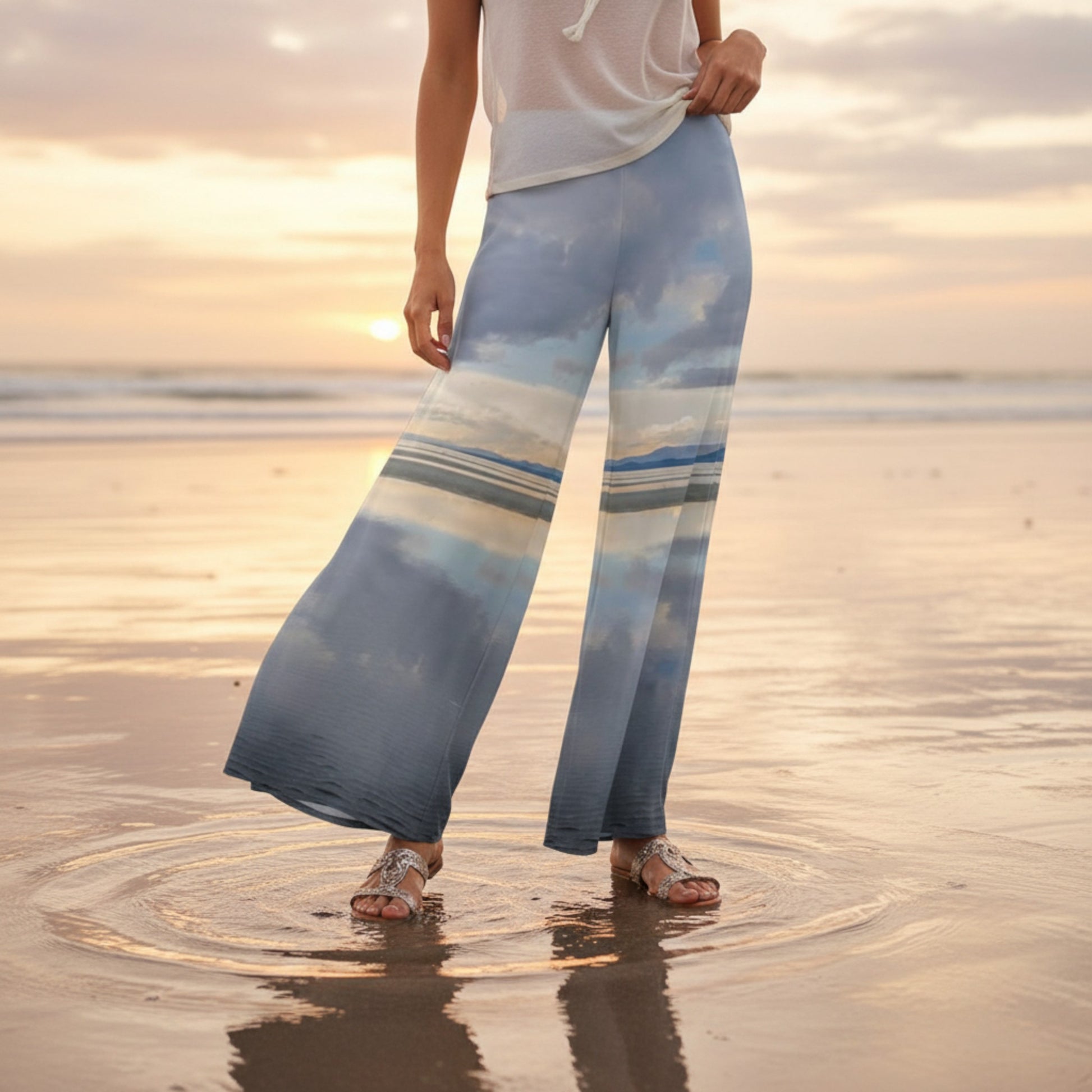 Person wearing blue pants with a sunset design on a beach
