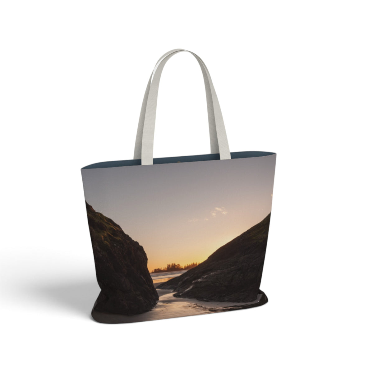 A tote bag with a printed landscape photograph of a river flowing between rocky cliffs at sunset, featuring white shoulder straps, shown on a plain white background.