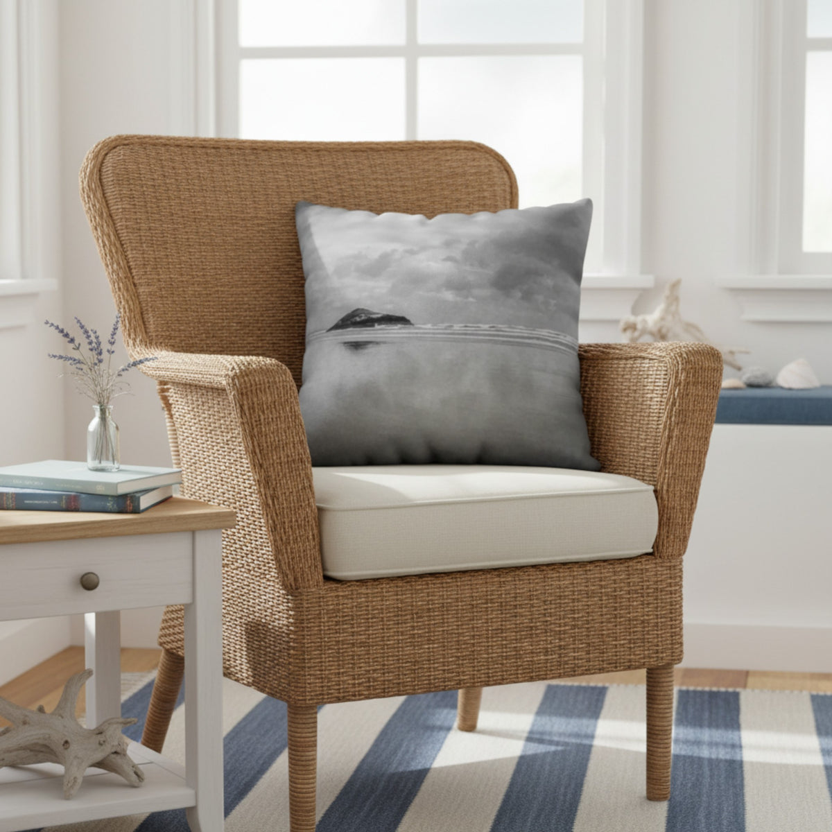 A throw pillow with a printed image of a coastal scene, featuring a pillow cover with a grayish-blue hue and a visible island in the distance.