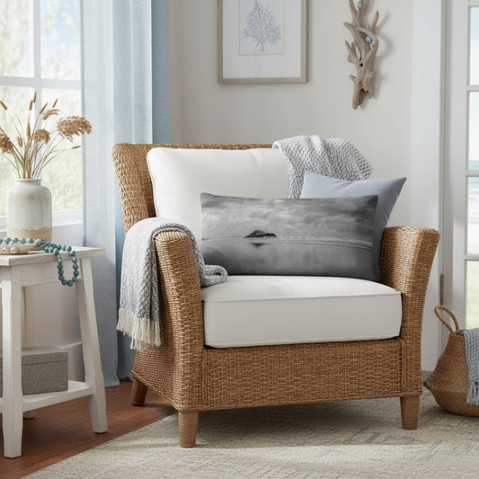 A throw pillow with a printed image of a coastal scene, featuring a pillow cover with a grayish-blue hue and a visible island in the distance.