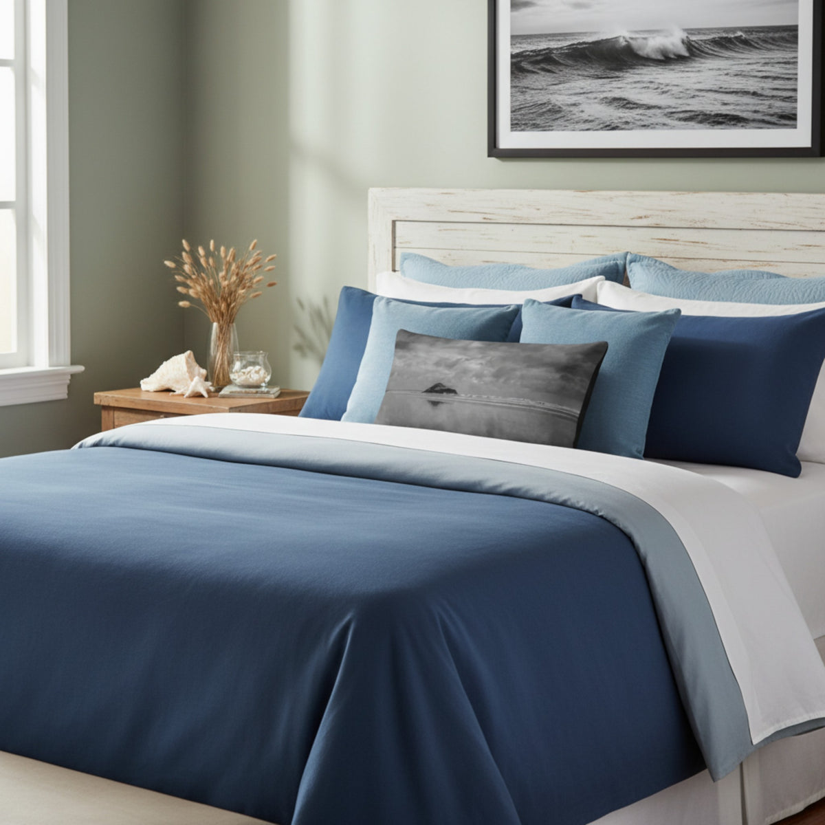 A throw pillow with a printed image of a coastal scene, featuring a pillow cover with a grayish-blue hue and a visible island in the distance.