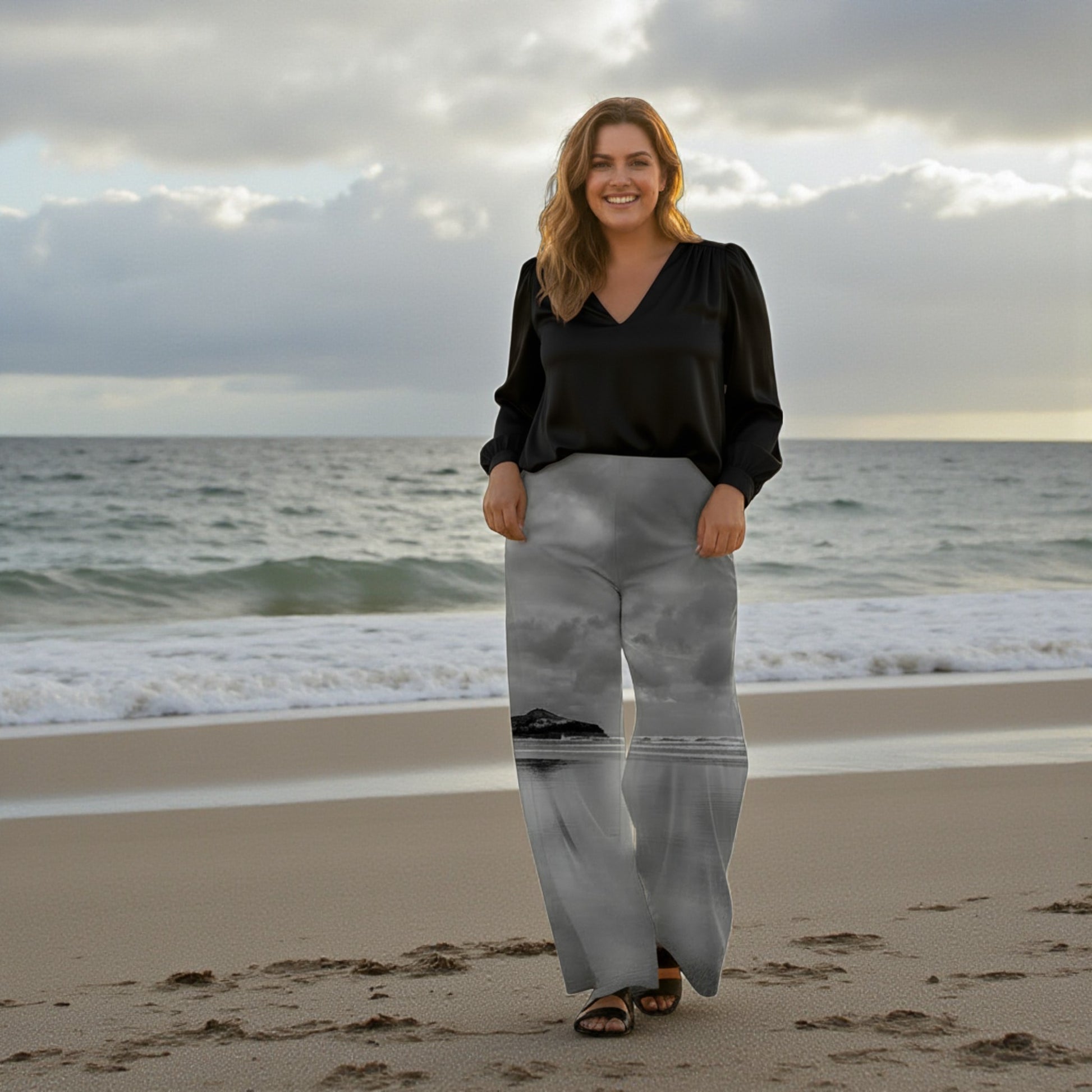 Woman standing on a beach with ocean waves and cloudy sky in the background