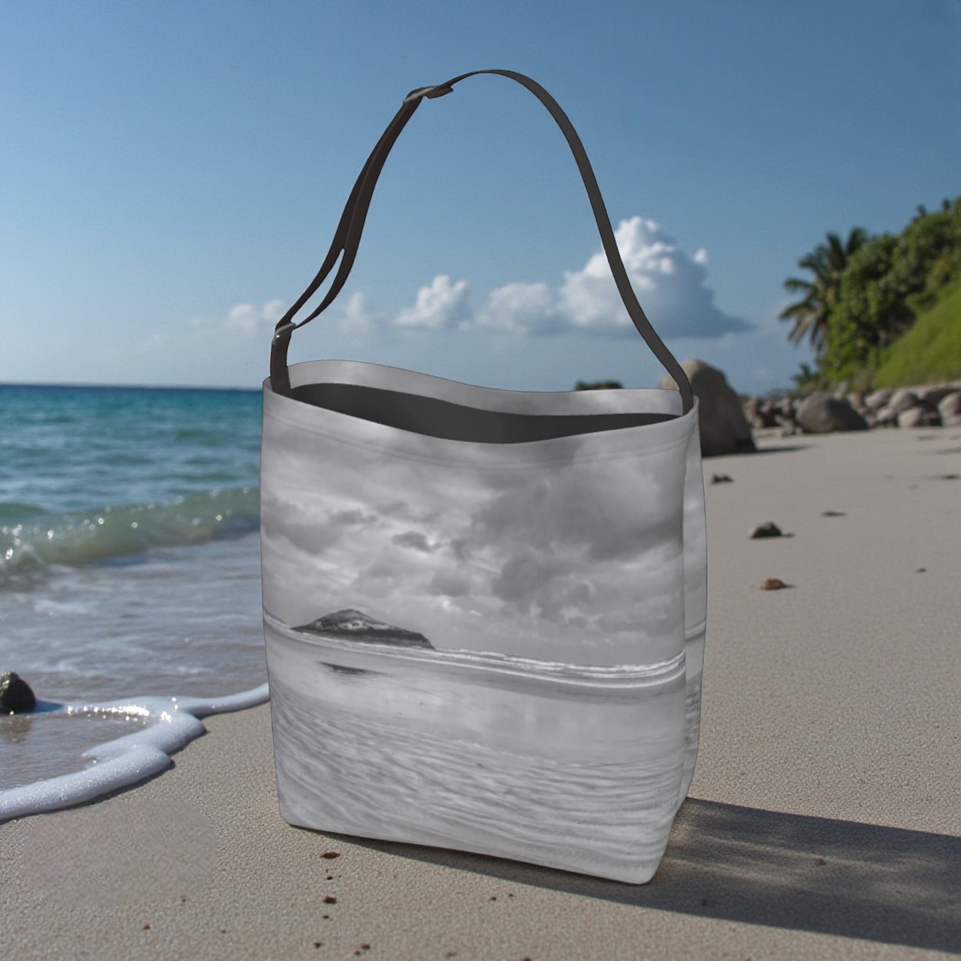 Tote bag with beach design on a sandy beach with ocean and sky in the background