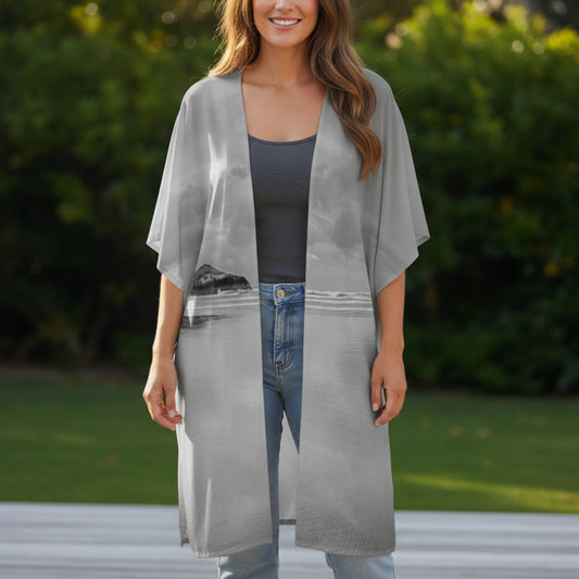 Woman wearing a long, light gray kimono-style garment with a blurred green outdoor background