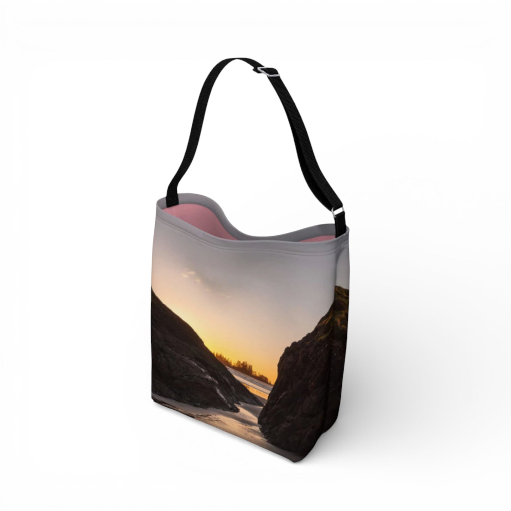 Tote bag with a scenic design of a sunset over water and mountains on a white background
