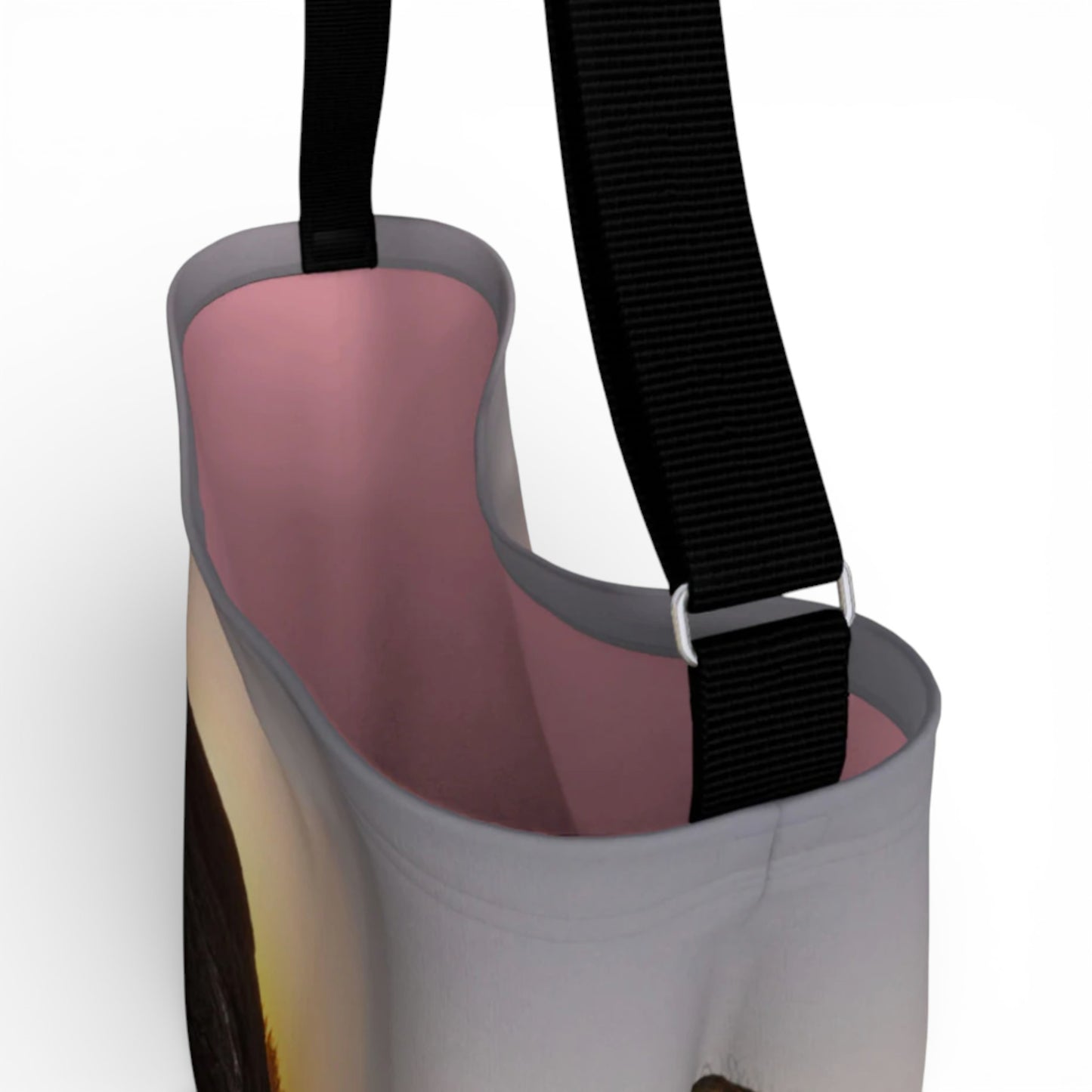 Close-up of a pink and gray bag with a black strap on a white background