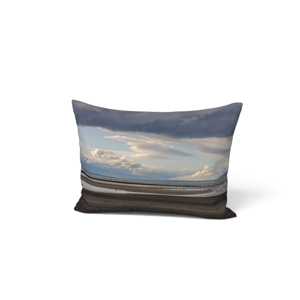 A rectangular throw pillow featuring a photographic print of a beach landscape under a cloudy sky, shown against a plain white background.