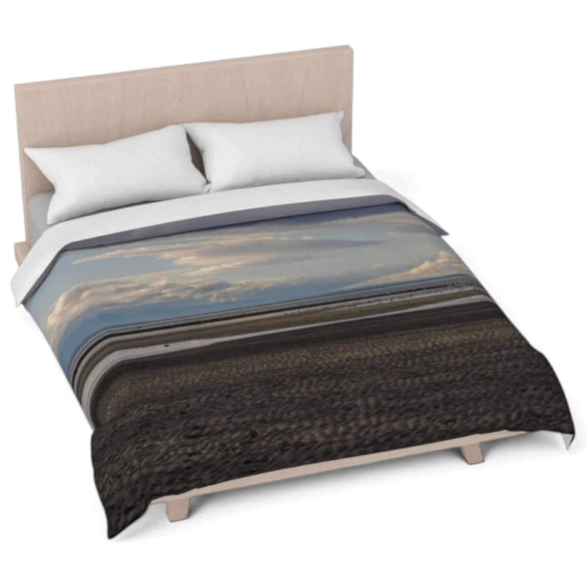 A bed dressed with a duvet cover featuring a landscape print of a beach or field under a cloudy sky, styled with two white pillows and a light wood headboard on a white background.