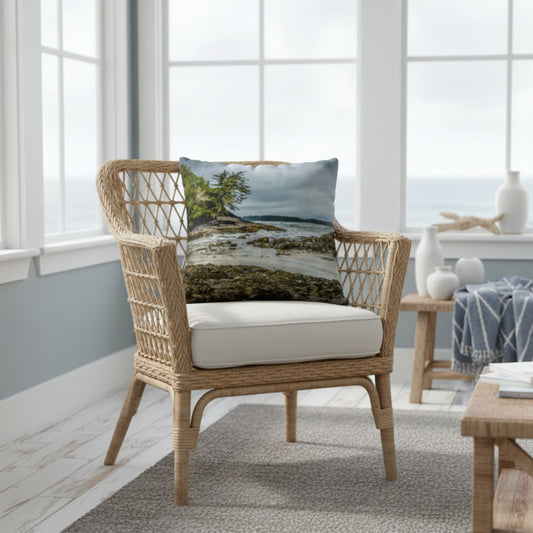 A throw pillow cover featuring an image of a coastal scene with rocks and trees on a beach.