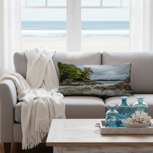 A throw pillow cover featuring an image of a coastal scene with rocks and trees on a beach.
