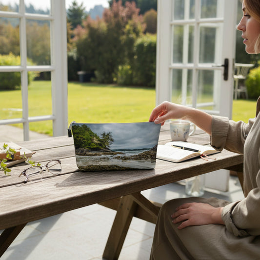Woman using a laptop with a scenic cover outdoors on a wooden table.