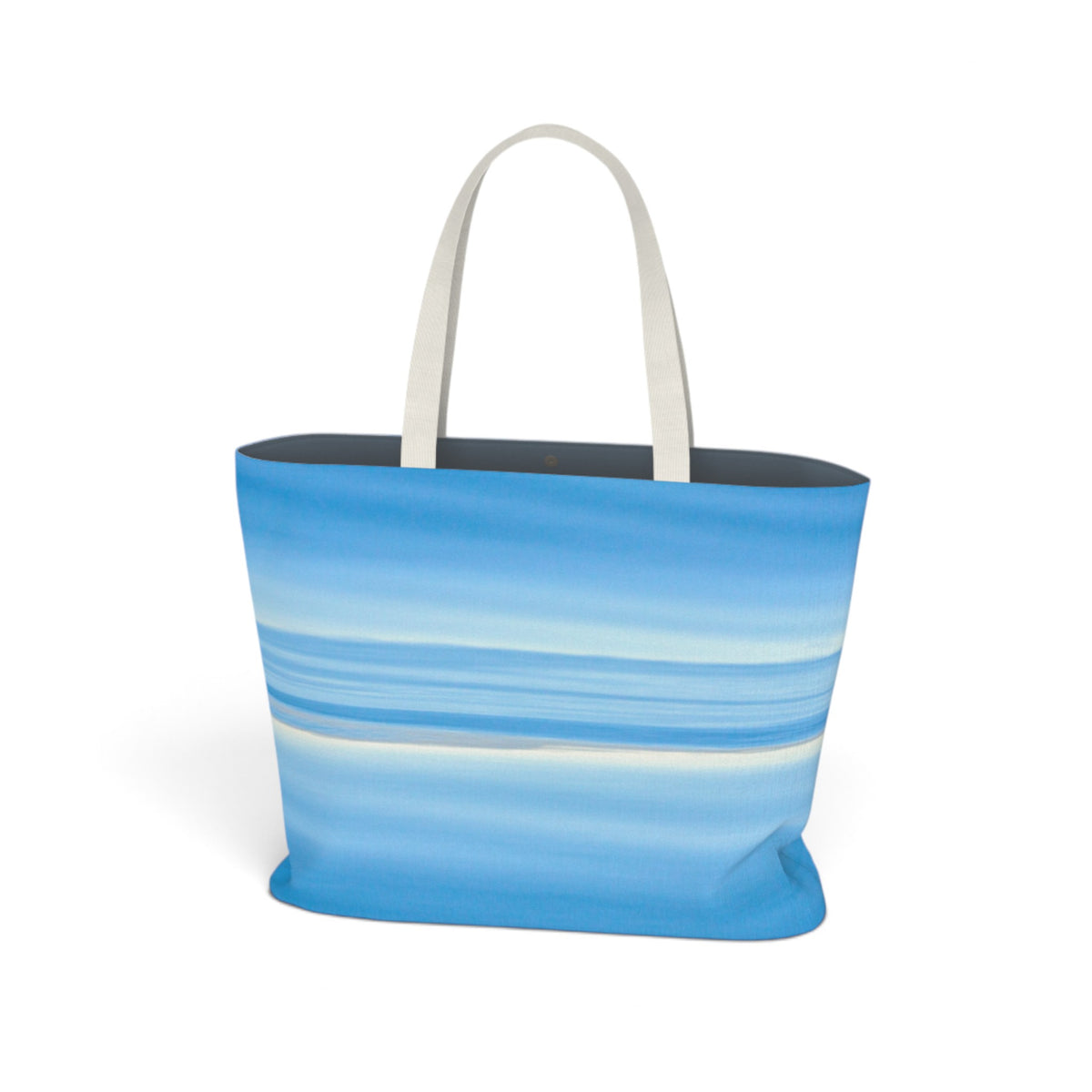 A tote bag featuring a blue and white horizontal striped pattern resembling ocean waves, with off-white shoulder straps, shown on a plain white background.