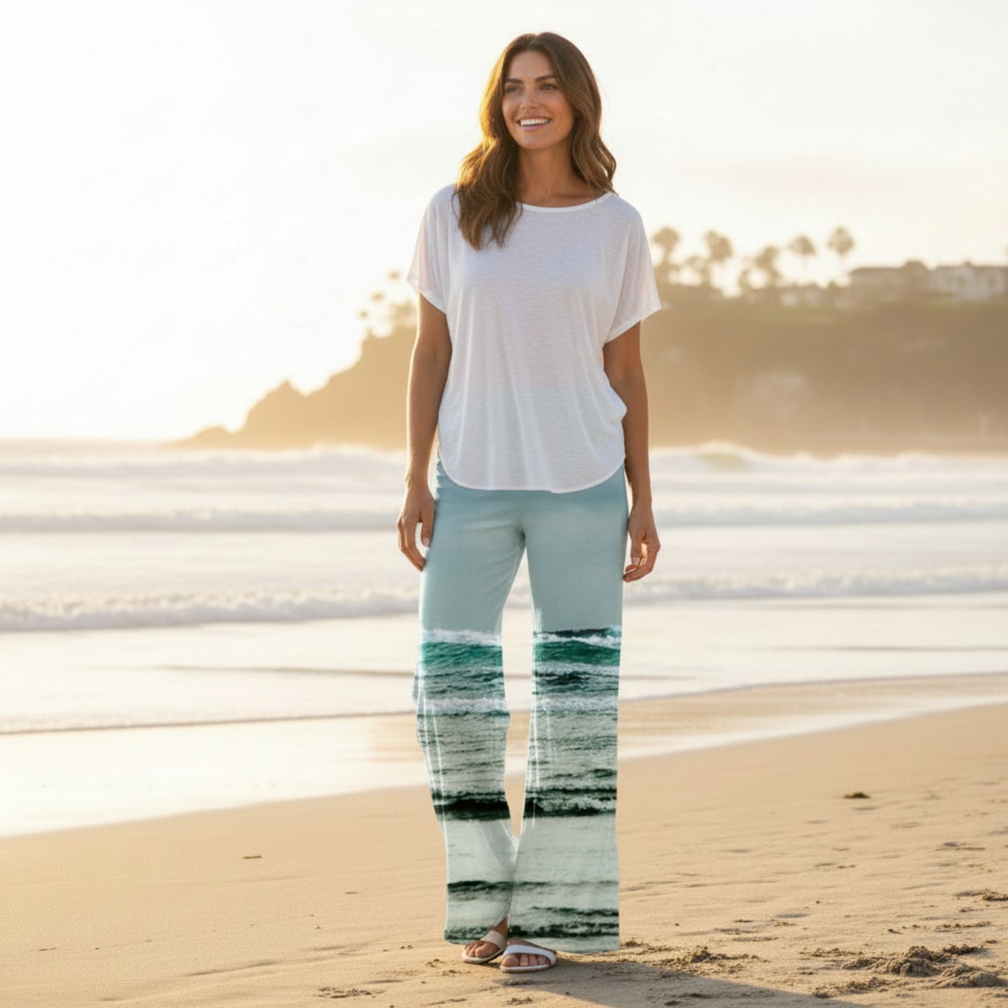 Woman standing on a beach with a scenic reflection of water on her pants.