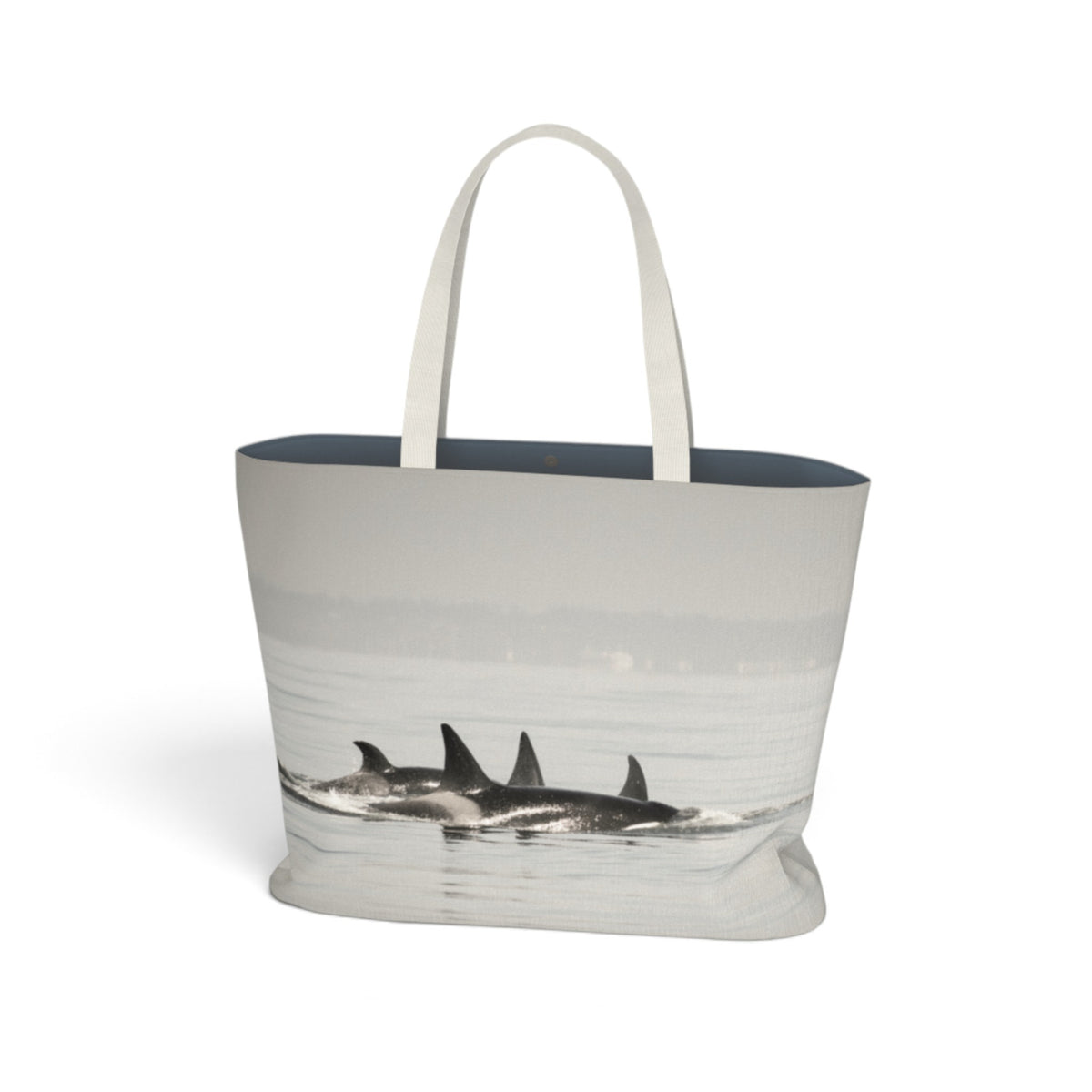 A tote bag with a photographic print of killer whales surfacing in the water, featuring white fabric handles and a dark navy blue interior lining, shown against a plain white background.