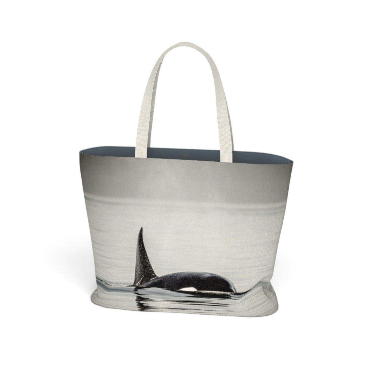 A tote bag featuring a photographic print of an orca whale surfacing in misty water, with white fabric handles and a dark gray interior lining, shown against a plain white background.