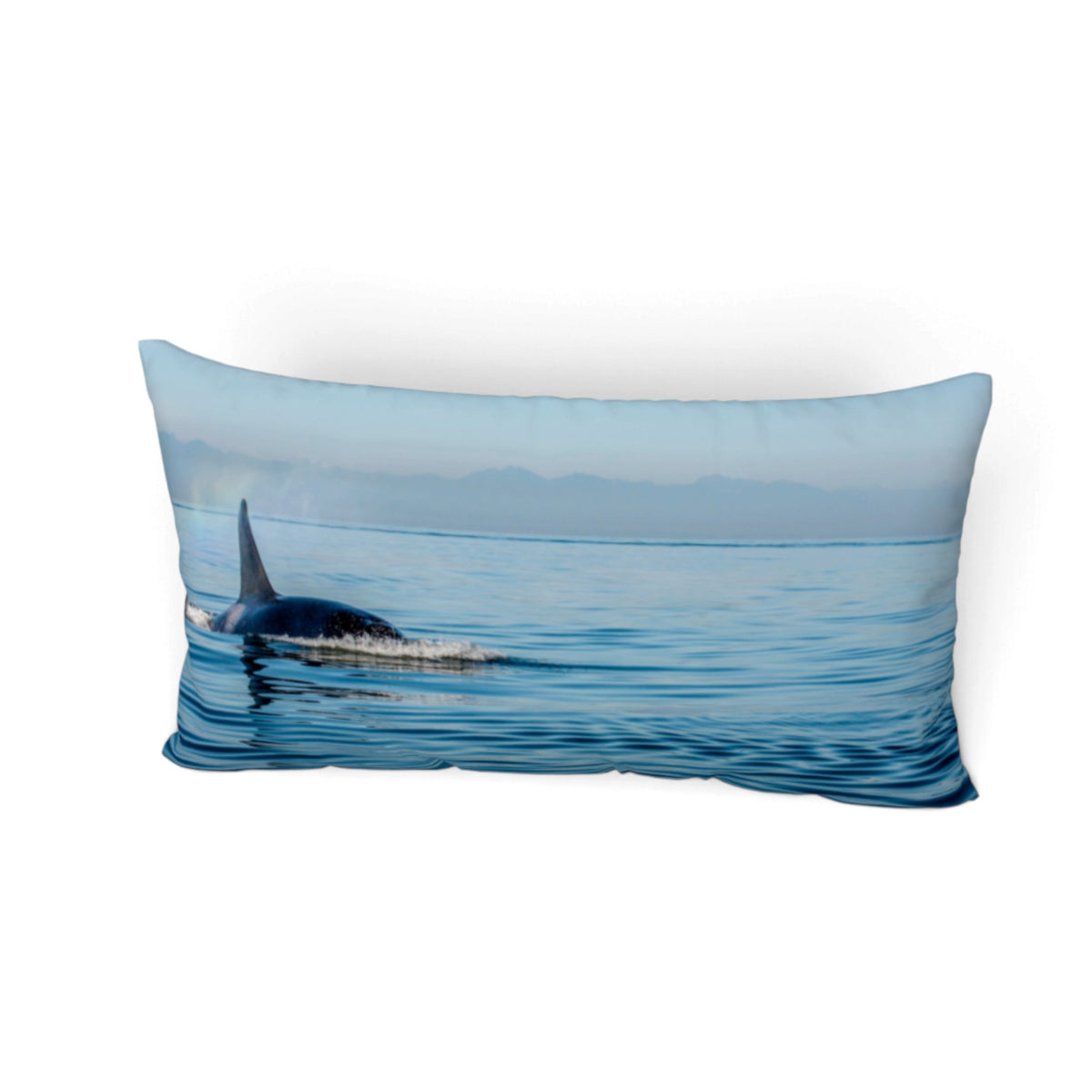 A rectangular lumbar pillow featuring a photographic print of an orca whale surfacing in blue ocean waters under a pale sky, shown against a plain white background.