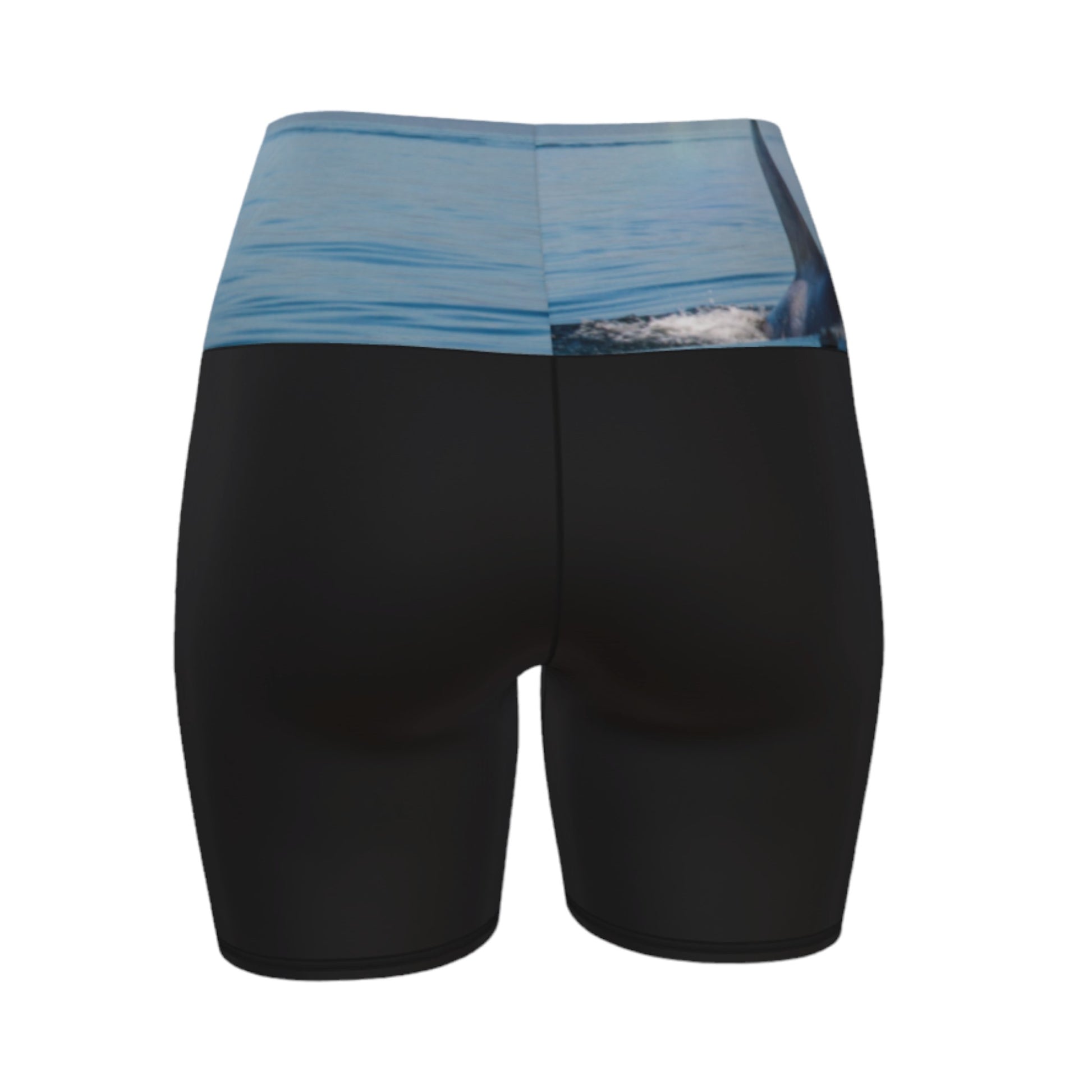 Orca Spray yoga shorts features a image of an orca exhaling on the ocean. This image is printed on the waistband and the rest of the shorts is black.