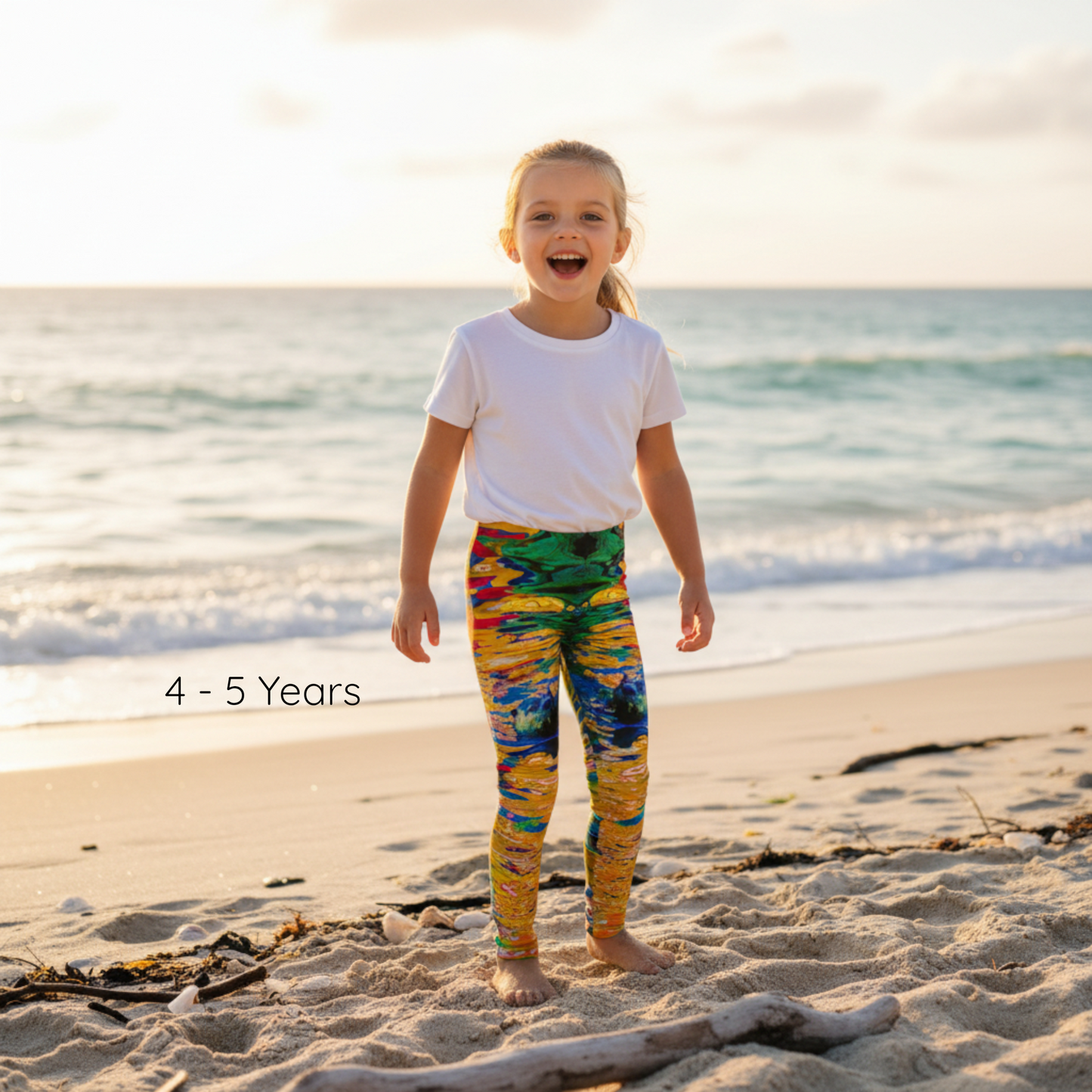 Child wearing colorful leggings and a white shirt on a beach