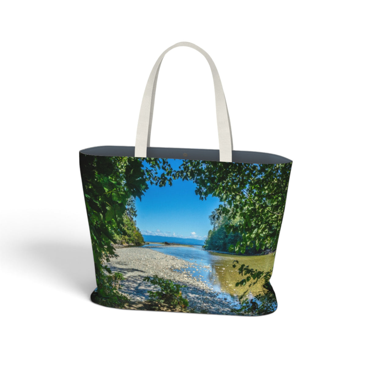 A tote bag featuring a scenic landscape print of a river flowing through a forest, with white shoulder straps, shown on a plain white background.
