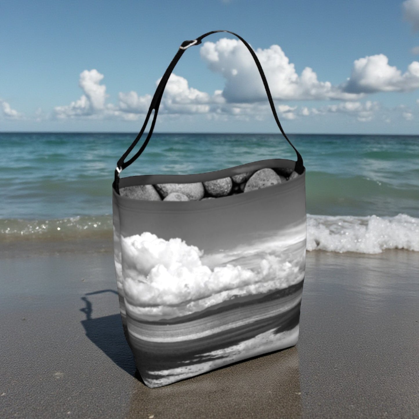 Tote bag with beach design on a sandy beach with ocean in the background