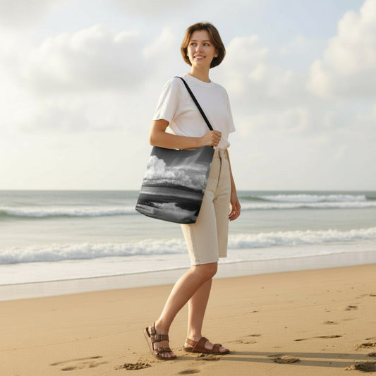 Woman walking on a beach with a tote bag, ocean and sky in the background