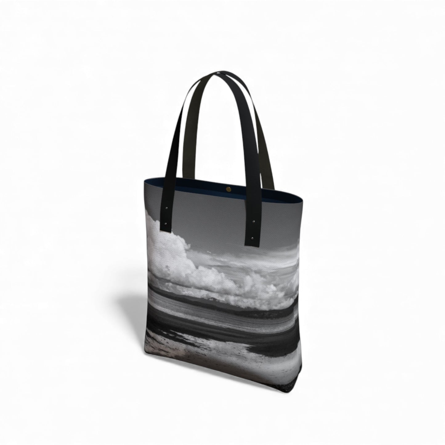 Tote bag with a black and white design of clouds and water on a white background