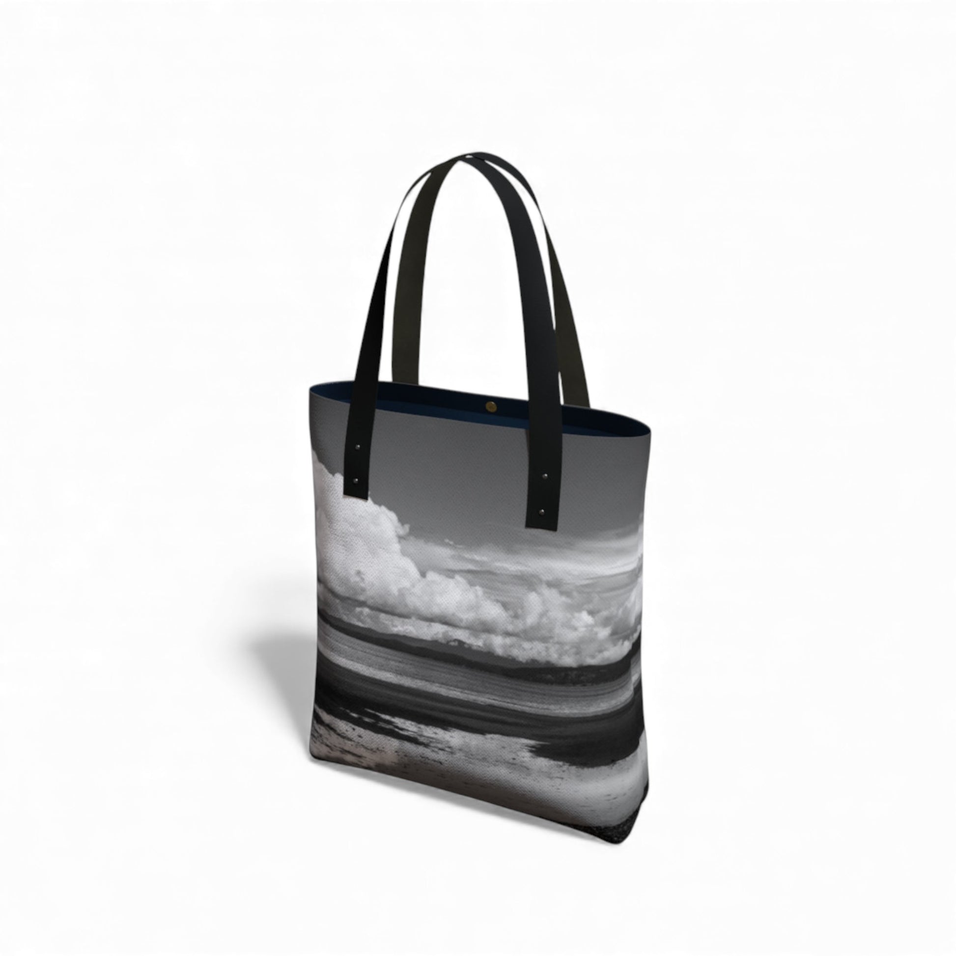 Tote bag with a black and white design of clouds and water on a white background