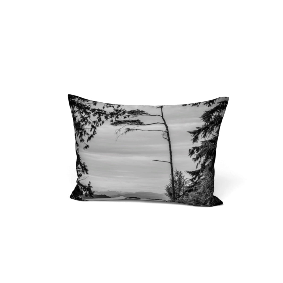 A rectangular throw pillow featuring a black and white landscape photograph of pine trees and a misty forest scene, shown against a plain white background.