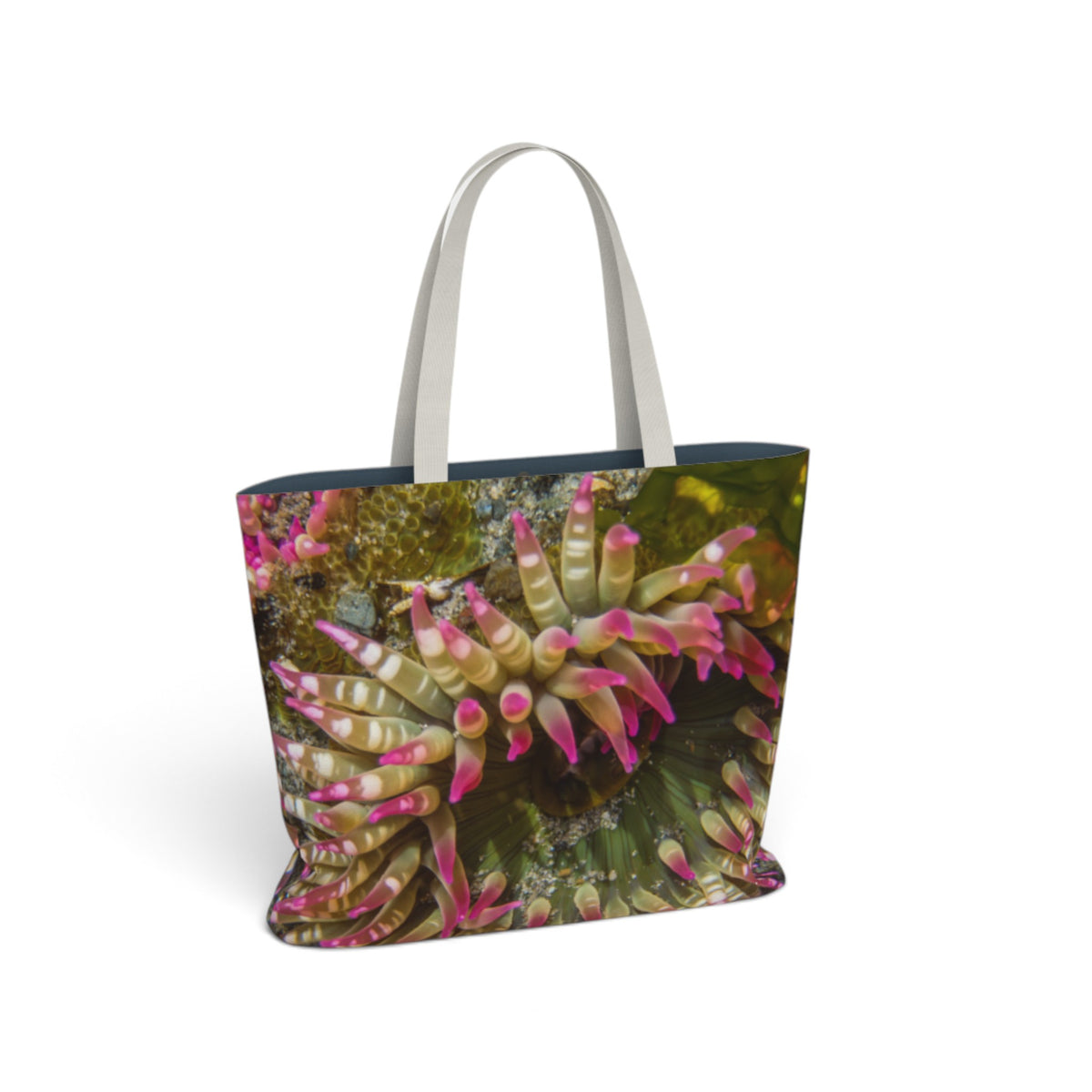 A tote bag featuring a close-up photograph of pink and green sea anemones, with light gray shoulder straps, shown on a plain white background.
