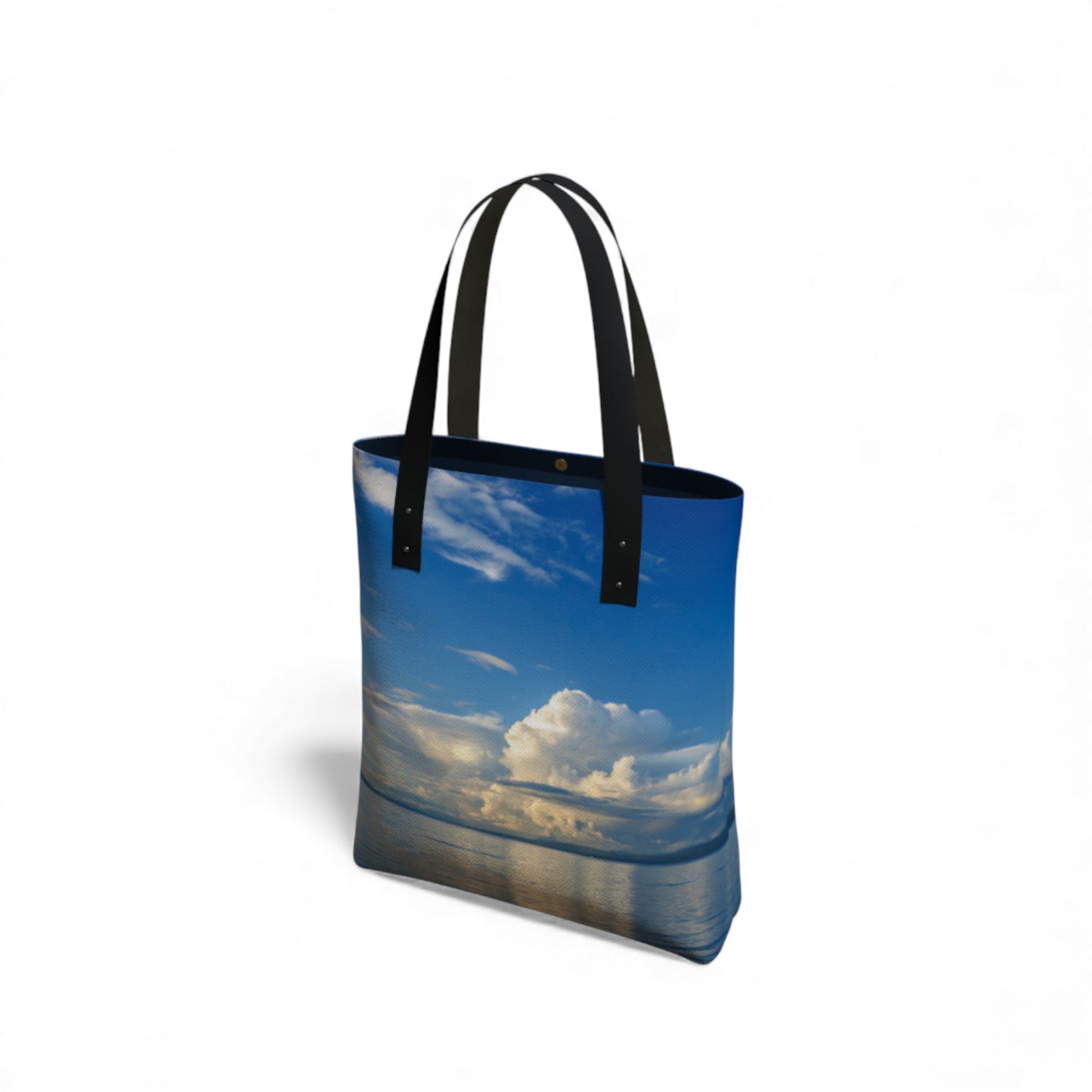 Tote bag with a scenic design of a blue sky and clouds on a white background