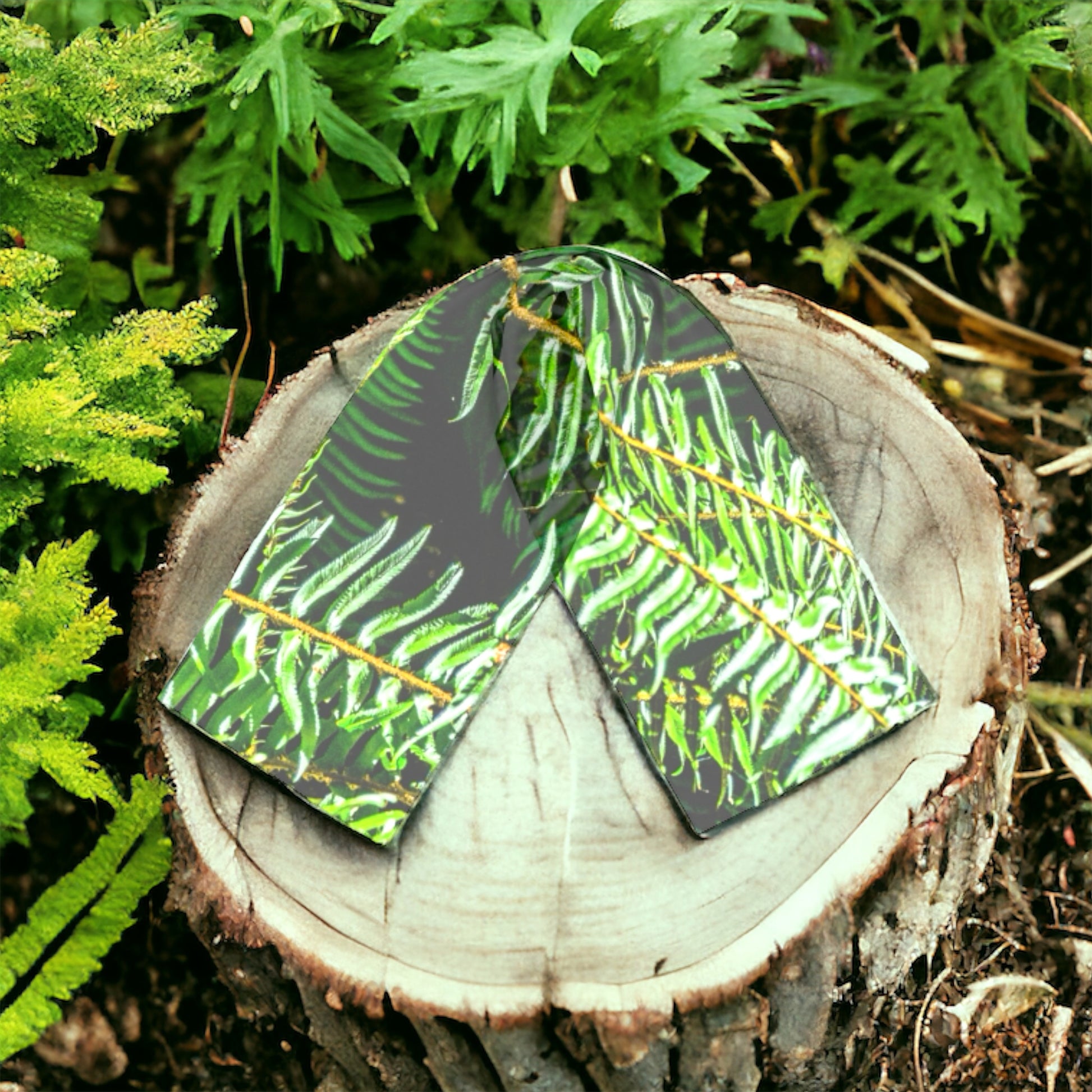 Rainforest long scarf is shown on a wood tree stump.