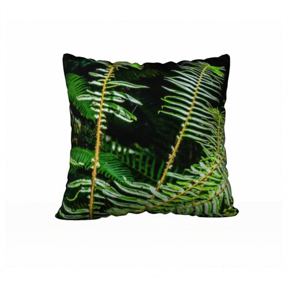 A square throw pillow featuring a detailed print of green fern leaves on a black background, shown against a plain white studio backdrop.
