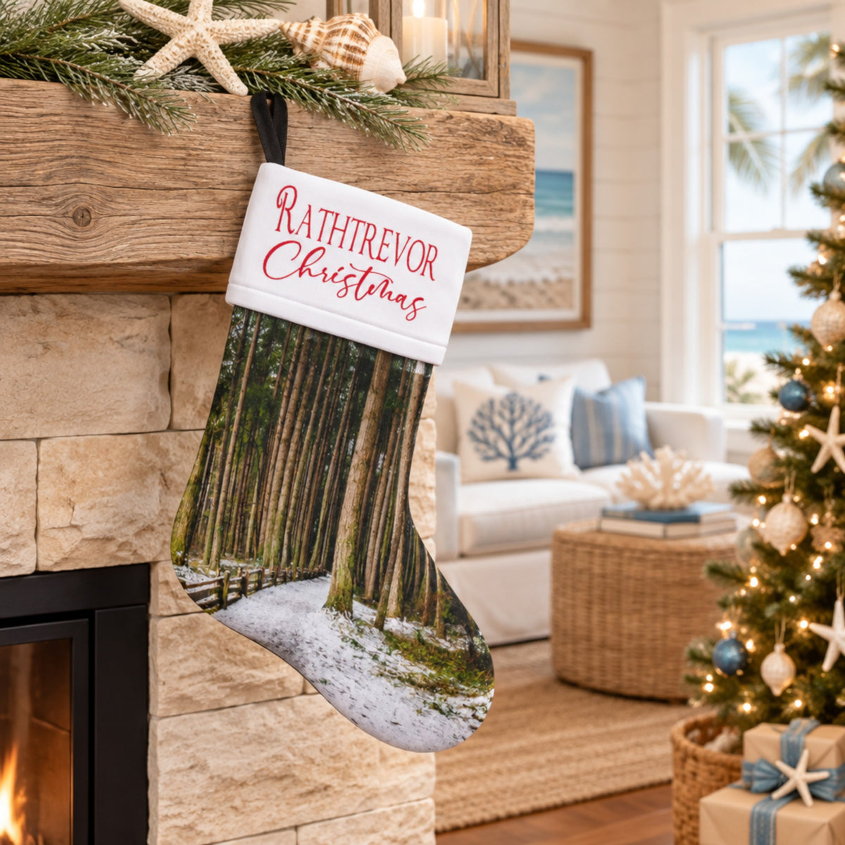 A personalized Christmas stocking with a forest and snow print hangs from a wooden mantel in a cozy living room. The cuff is white with the text 'RATHTREVOR Christmas' in red script.