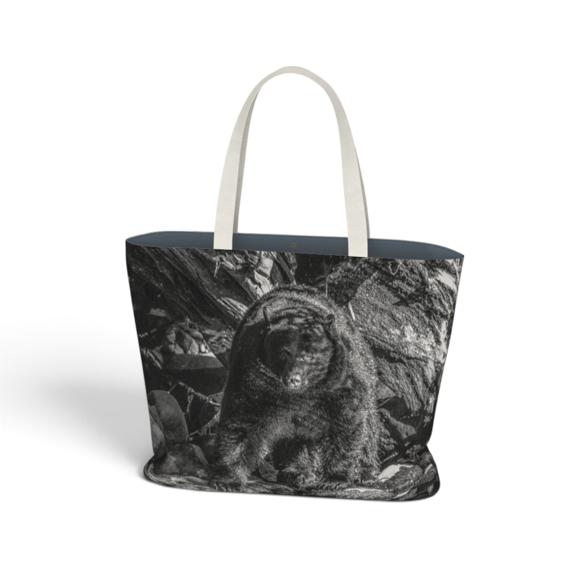 A tote bag featuring a black and white photographic print of a mountain lion on the front, with off-white fabric handles and a dark navy blue interior lining, shown against a plain white background.