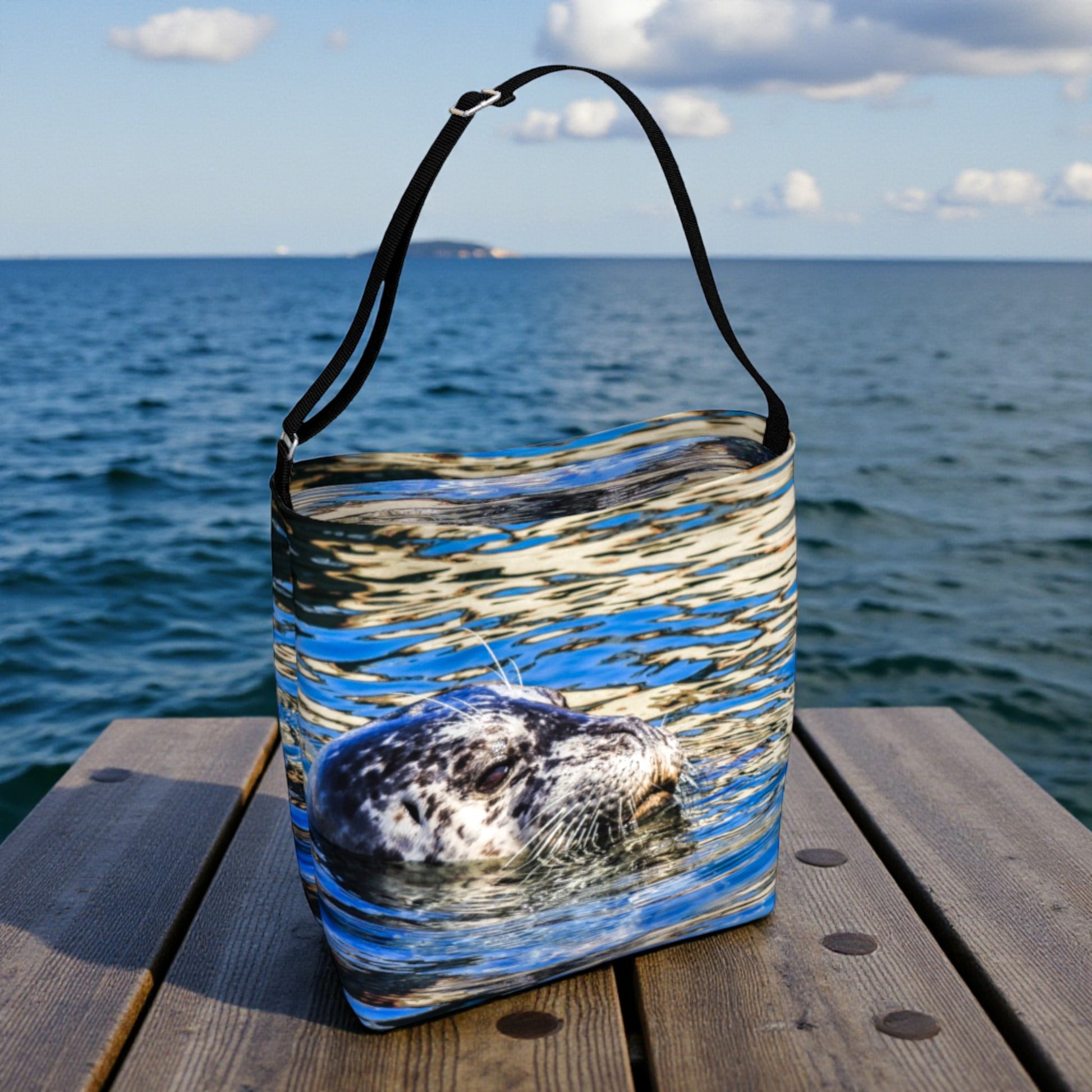 
Tote bag with a seal design on a wooden dock by the ocean