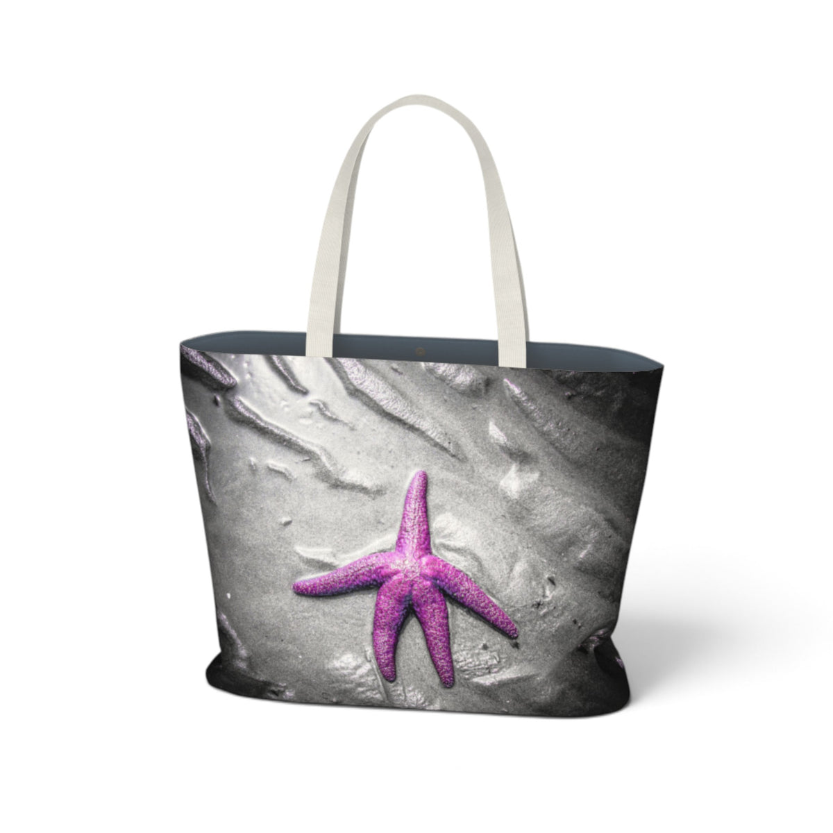 A tote bag with a gray and black textured print featuring a bright pink-purple starfish, complete with light beige shoulder straps, shown on a white background.