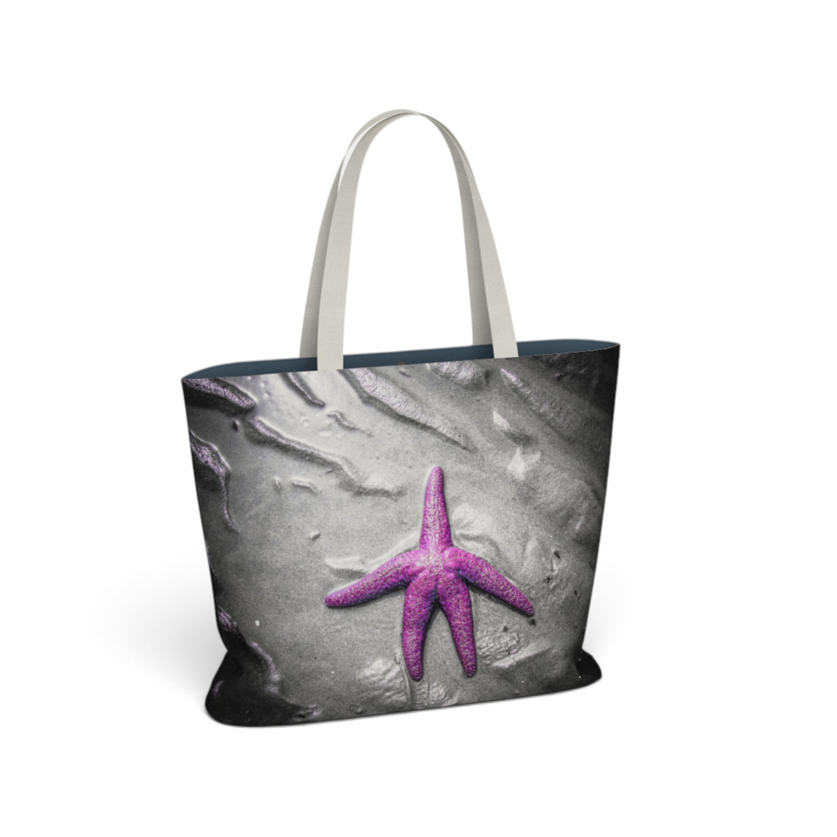 A tote bag featuring a printed design of a purple starfish on a gray textured background, with light beige shoulder straps, shown on a plain white background.