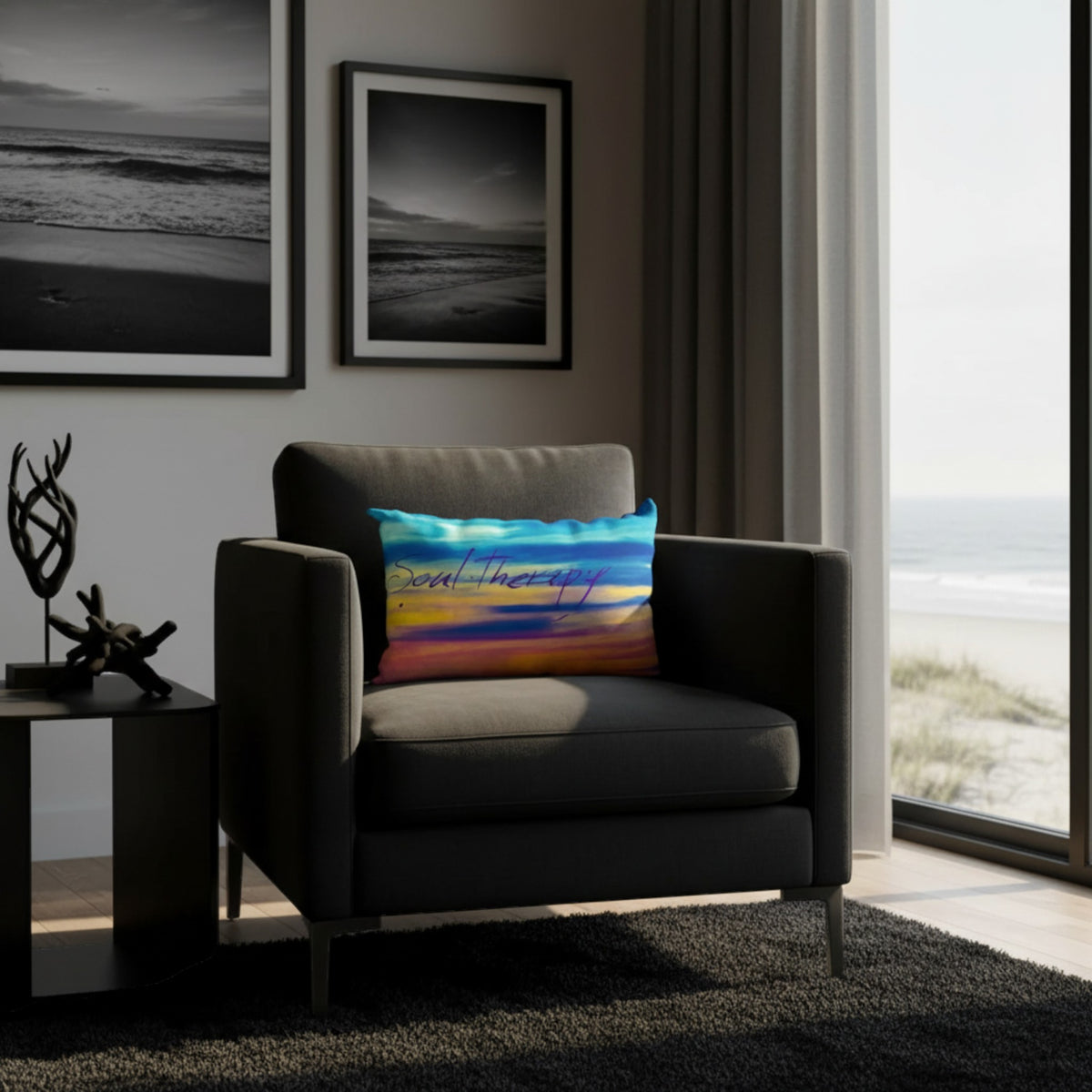 A dark gray armchair in a modern living room setting with a colorful 'Soul Therapy' throw pillow, next to a side table and a large window overlooking the ocean.