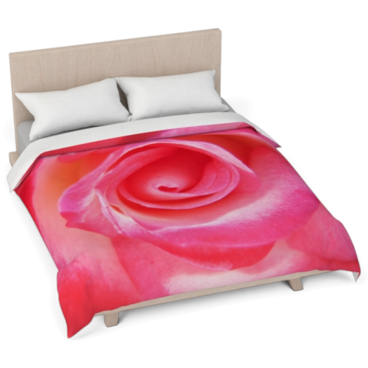 A bed with a large pink rose print comforter, white pillows, and a light wood headboard on a white background.