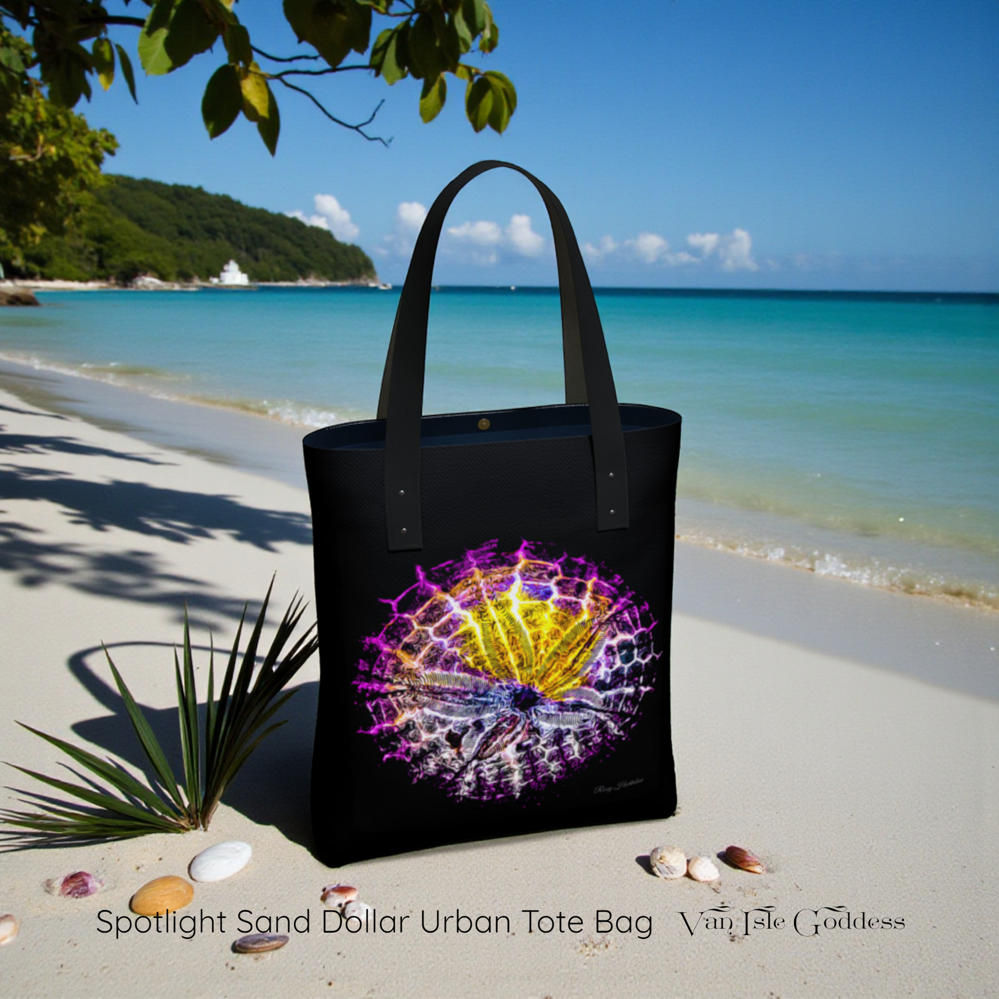 Black tote bag with colorful design on a sandy beach with ocean and sky in the background