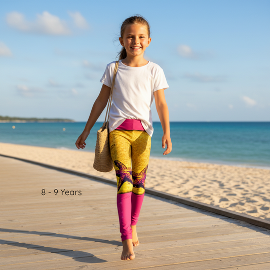 Young girl walking on a wooden boardwalk by the beach, wearing colorful leggings and a white shirt.