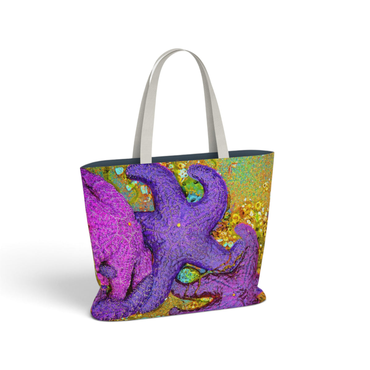 A tote bag with a colorful abstract starfish print in purple, pink, and gold, featuring light gray shoulder straps, shown on a white background.