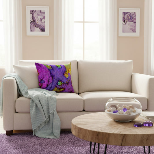 A cream-colored fabric sofa in a bright living room setting, styled with a vibrant purple and magenta abstract patterned throw pillow and a light blue-green fringed throw blanket. In front of the sofa is a round wooden coffee table with a glass bowl of seashells, and the floor is covered in a purple shag rug.