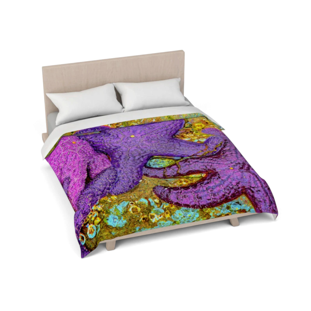A bed dressed with a colorful abstract duvet cover featuring a large purple starfish motif over a gold, turquoise, and magenta background, shown on a light wood bed frame with white pillows against a white studio background.