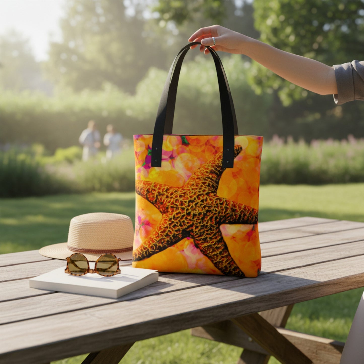 Colorful tote bag with a bright starfish  design on a wooden table outdoors.