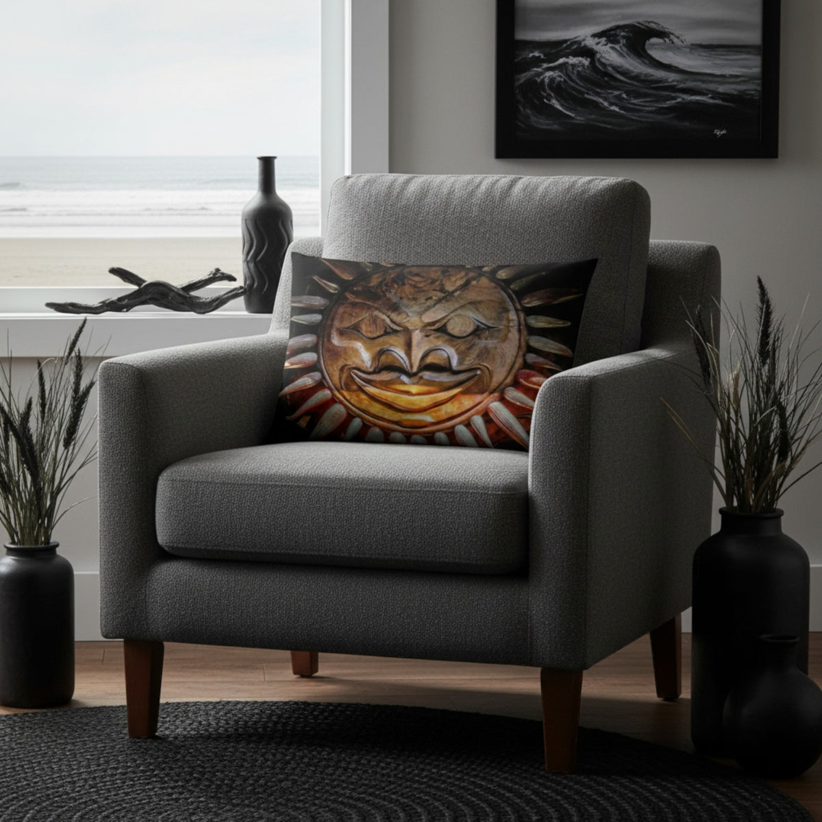 A gray upholstered armchair in a styled room setting, featuring a square throw pillow with a detailed sun face illustration in warm golden, orange, and brown tones.