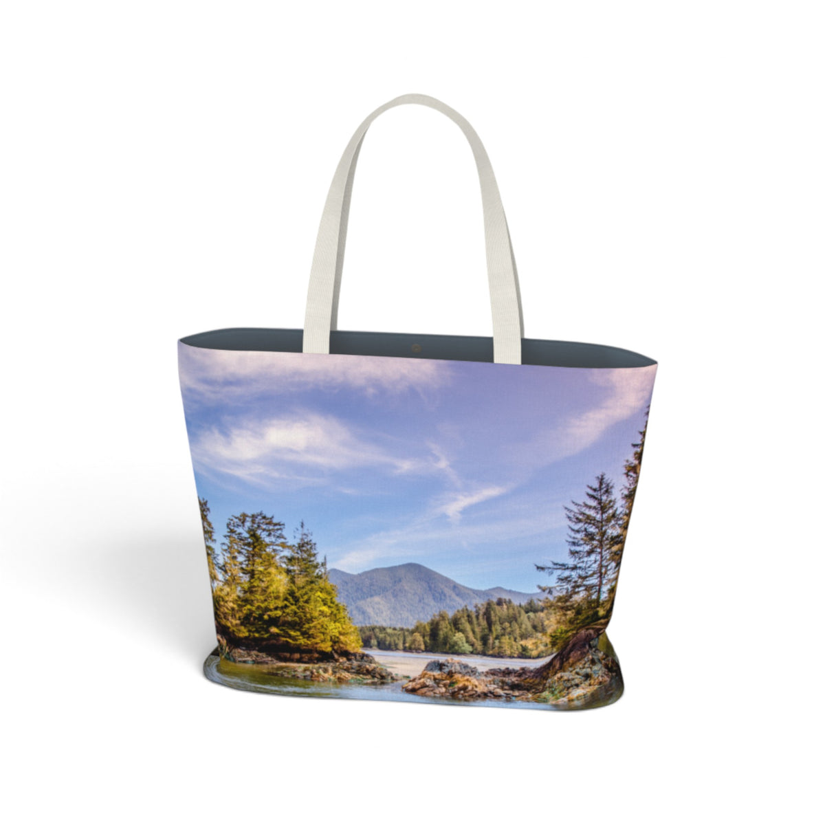 A tote bag featuring a scenic landscape print of a mountain, river, and pine trees under a blue sky, with light gray fabric handles, shown on a white background.